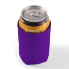 A soda can in a purple neoprene sleeve.