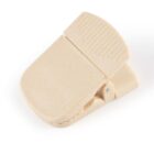 A beige plastic clip with a ridged grip on a white background.