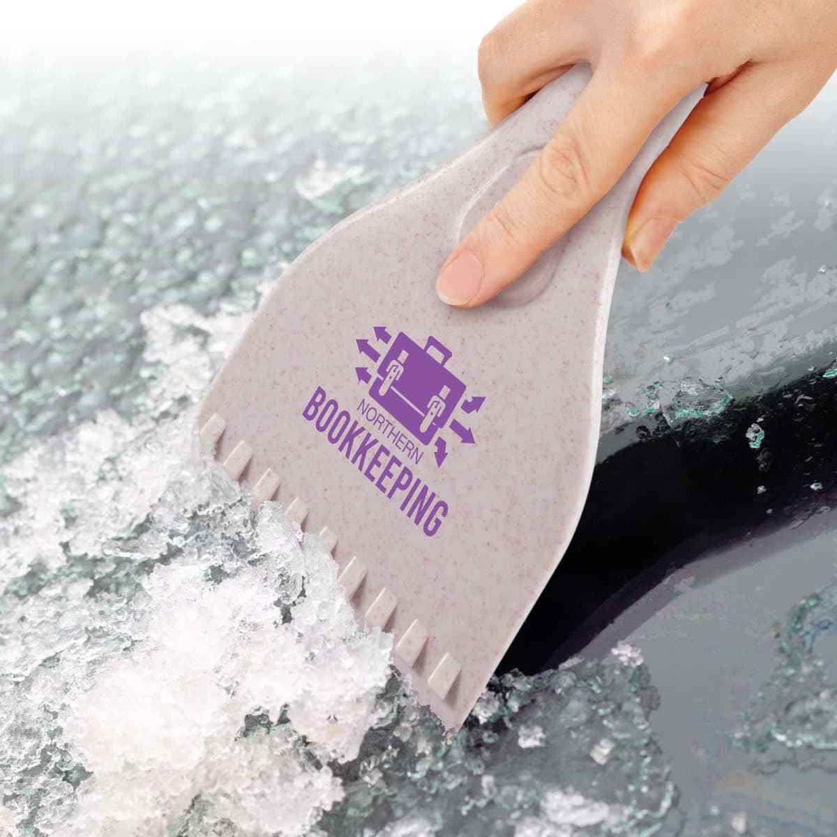 Hand using a branded ice scraper to remove ice from a car window.