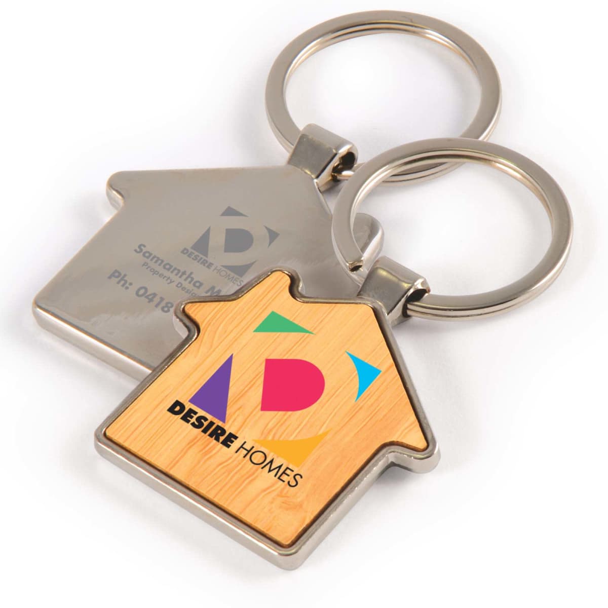 House-shaped keychains with colorful Desire Homes logo and contact details.