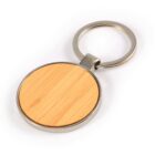 Round keychain with a bamboo wood center and metal edging on a white background.