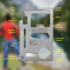 Multi-tool card labeled with features like can opener, ruler, and screwdriver, against a blurred nature background.