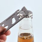 Multi-tool being used to open a bottle with a metal cap.
