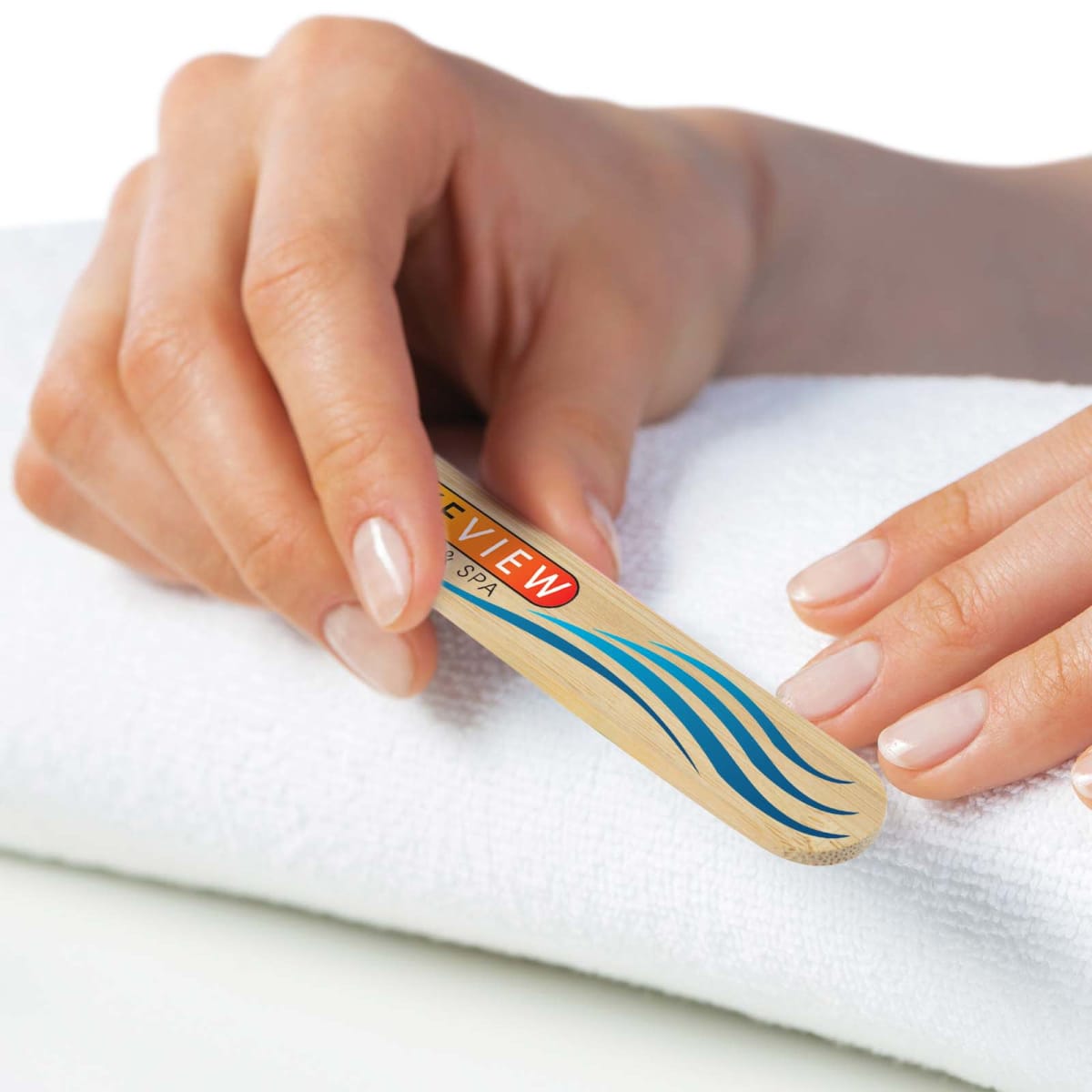 Person holding a nail file over a white towel, preparing to manicure nails.