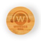 A round wooden coaster with a logo of a W inside headphones, and the text WONDER MEDIA below it.