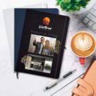 A WestBrook Apartments brochure titled "Executive Living" on a marble surface with notebooks, pen.