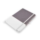A closed gray fabric notebook with a white side strip and an elastic band.