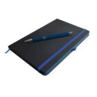 A black notebook with a blue elastic band is placed on a surface. A navy blue pen with silver accents rests on top of the notebook. The notebook has rounded edges and a ribbon marker.
