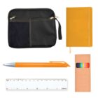 A flat lay of stationery items: a black zippered pouch with mesh pocket, an orange notebook, an orange pen, a set of colored pencils in a brown box, and a clear 15 cm ruler.