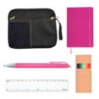 A collection of stationery items including a black zippered pouch with mesh pocket, a pink notebook with a ribbon bookmark, a pink pen with silver tip, a white ruler, and a set of colored pencils in a cardboard box.