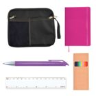 A black zippered pouch, a pink notebook with a ribbon bookmark, a purple pen, a box of colorful pencils, and a white ruler are arranged on a white background.