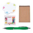 Assorted office items on a white background, including a cloud-shaped sticky note pad with colorful tabs, a small spiral-bound notebook, a clear bag of jelly beans, and a green pen.