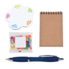 A small spiral notebook, a flower-shaped sticky note pad with colorful tabs, a packet of assorted jelly beans, and a blue retractable pen are arranged on a white background.