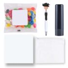 A collection of items includes a small bag of colorful jelly beans, a novelty pen with a smiling face topper, a black cylindrical case, a blank microfiber cloth, and a transparent zippered pouch.