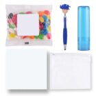 A collection of items including a packet of colorful jelly beans, a blue pen with a smiley face topper, a blue cylindrical container, a white cloth, and a transparent zippered pouch, all arranged on a white background.