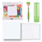 A collection of items: a packet of colorful jelly beans, a green pen with a smiley face topper, a green cylindrical container, a light green cloth, and a small transparent zippered pouch.