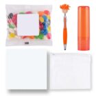 Assortment of items: a pack of colorful jelly beans, an orange pen with a novelty topper, an orange cylindrical lip balm, a white microfiber cloth, and a small white zippered pouch.