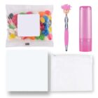 A set of colorful items including a bag of multicolored jelly beans, a pen with a pink top adornment, a pink cylindrical lip balm, a white microfiber cloth, and a white zippered pouch.