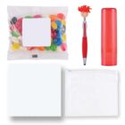 Image of a promotional gift set including a small bag of colorful jelly beans, a red pen with a smiling face topper, a red lip balm tube, a white microfiber cloth, and a clear zippered pouch.