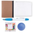 Assorted office and promotional items on a white background: a brown notebook with a black spine, a clear pouch, a white and blue pen, a bag of colorful jelly beans, and a blue stress ball.