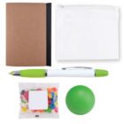 A collection of items including a brown notebook with a black spine, a white zippered pouch, a green and white pen, a green stress ball, and a packet of colorful jelly beans.
