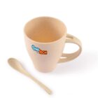 A beige speckled mug with a handle, featuring a colorful logo on the front. The mug is paired with a matching beige speckled spoon, both set against a plain white background.