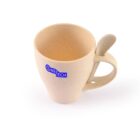A beige speckled mug with a handle holding a matching spoon. The mug features a blue ONETECH logo. The handle is designed with a slot to securely hold the spoon. The background is plain white.