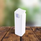 A rectangular white plastic container with a flip-top lid is placed on a wooden surface. The background is softly blurred with green and beige tones, suggesting an outdoor setting.