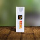 A white USB power bank with the logo REAL Electricity is placed on a wooden surface. The background is a blurred green gradient.