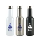 Three insulated bottles with Yoga Day written below a meditative pose silhouette. The bottles are white, metallic silver, and black, each with a silver cap.