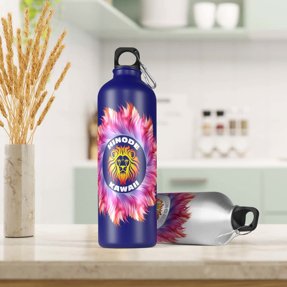 Two water bottles on a kitchen counter; one is upright and blue with a lion logo and the text SHINODE KAWAII! with a pink feather design. The other bottle, silver and blue, lies on its side. The kitchen background is softly blurred.