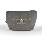 A gray zippered pouch with the Glow Wood logo, featuring a stylized flame design and the text Serenity Scented. The fabric has a textured appearance.