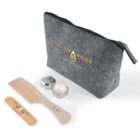 A gray zippered pouch with Glow Wood branding is displayed alongside a wooden comb and two small tins containing cosmetics. The items are arranged on a light background.