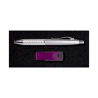 A silver pen with a metallic clip lies above a purple and gray USB flash drive on a black surface.