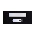 A white USB flash drive with a black circular detail is placed on a dark textured surface. Above it, there is a white rectangular object. The objects are centered in the image against the dark background.