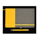 A closed notebook with a yellow and gray cover is centered on a black background. It has an elastic band and a ribbon bookmark. Below it lies a yellow ballpoint pen with metallic accents.