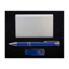 A flat lay of a silver business card holder, a blue pen with silver accents, and a blue USB flash drive on a black surface.