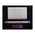 A silver business card holder, metallic pen, and purple USB flash drive are neatly arranged on a black surface.