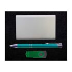 A flat lay of a silver cardholder, a green pen, and a green USB flash drive arranged on a black surface.