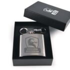 A stainless steel flask with a horse logo and Stallion Resources text is displayed inside an open black box. The box also contains a keychain and a steel clip, all set against a white background.