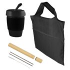 A black reusable coffee cup with a lid, a black foldable fabric bag, a collapsible beige tube case containing two metal straws, and a cleaning brush, all displayed on a white background.