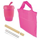 A pink reusable travel mug with lid, a pink foldable tote bag, two metal straws with cleaning brush, and a beige straw case with one open end are arranged against a white background.