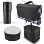 A black travel mug, a compact black and white portable speaker, a black insulated cooler bag, and a black carrying blanket with a checkered pattern are displayed against a white background.