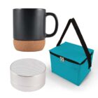 A black mug with a cork base, a small silver speaker, and a turquoise insulated lunch bag with a black handle against a white background.