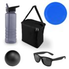 A collection of outdoor items including a gray water bottle with a flip-top, a black insulated lunch bag with a shoulder strap, a blue frisbee, a black rubber ball, and a pair of black sunglasses with dark lenses.
