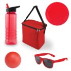 A collection of red items on a white background: a sport water bottle, an insulated lunch bag with a black strap, a frisbee, a rubber ball, and a pair of sunglasses.