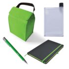 A collection of green-themed stationery and accessories including a green lunch bag, a clear flat water bottle, a green pen with silver accents, and a black notebook with a green spine and elastic band.