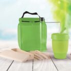 A green lunch bag, a transparent water bottle, a green reusable cup, wooden cutlery in a case, and a clear container are displayed on a wooden surface with a blurred nature background.