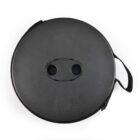A round, black carrying case with a textured surface. It has two holes and a handle attached to the side.