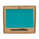 A teal notebook with an elastic band is placed inside a brown cardboard box, accompanied by a black pen with a green clickable top. The box has a circular cut-out for easy opening.